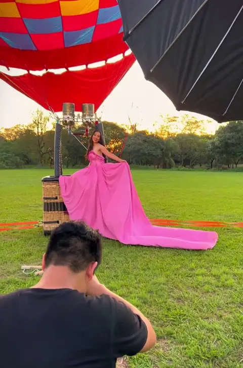 Josue fotografiando a una quinceañera junto a un globo aerostático