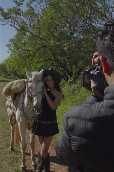 Josue con la cámara en una sesión de quinceañera con un caballo