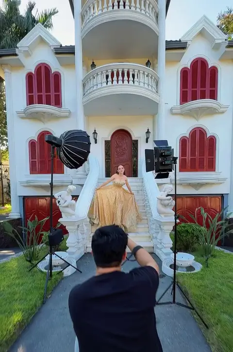 Josue fotografiando a una quinceañera frente a un castillo blanco